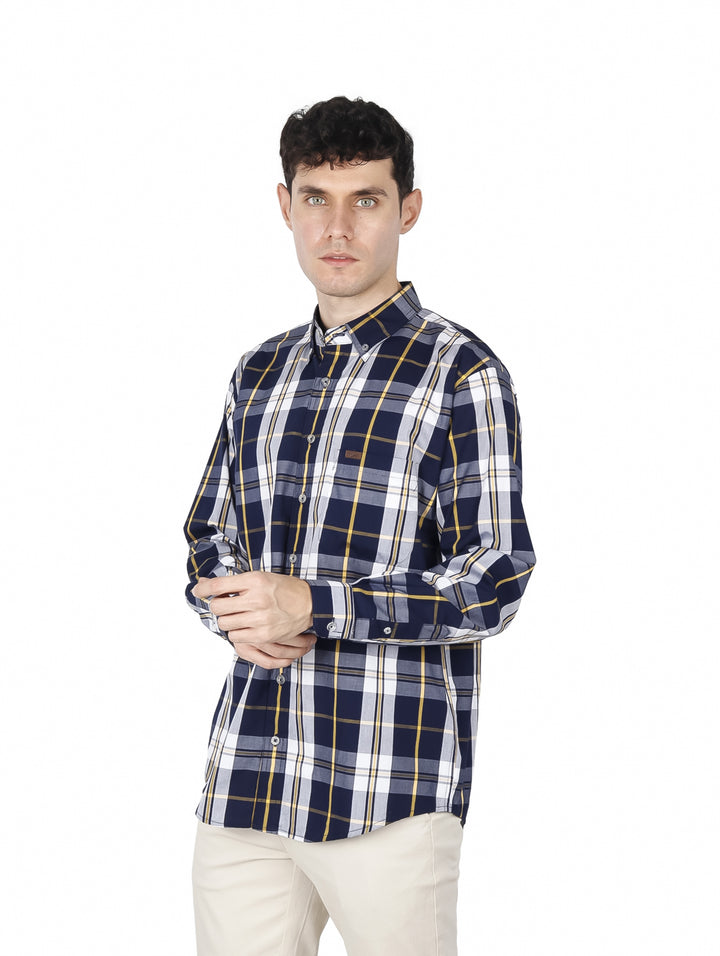 Hombre vistiendo una camisa de manga larga a cuadros en color azul marino, blanco y amarillo.