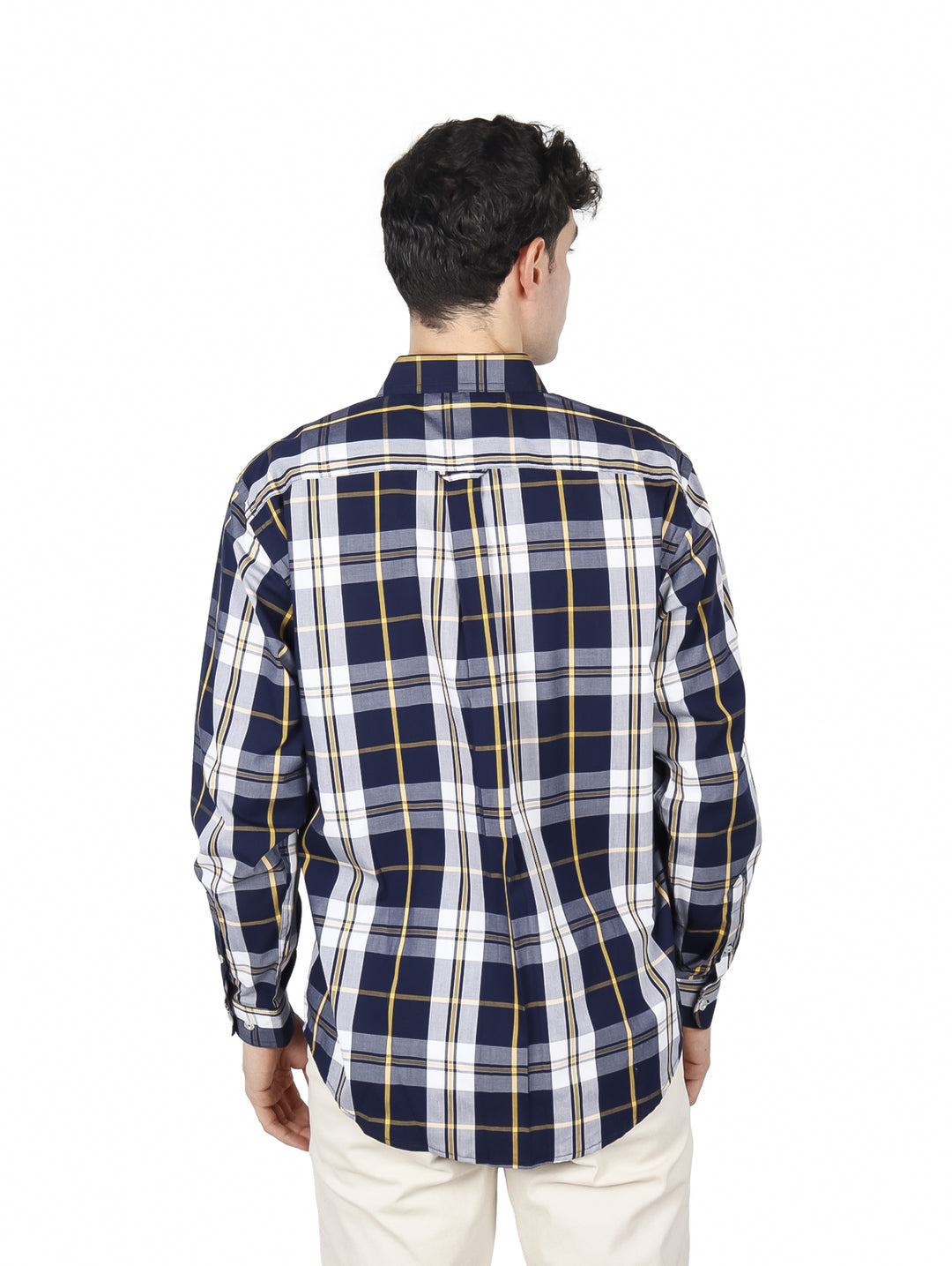 Hombre vistiendo una camisa de manga larga a cuadros en color azul marino, blanco y amarillo.