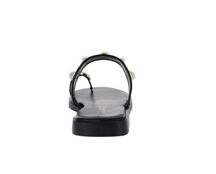 Sandalia plana color negro para mujer con detalles metálicos dorados ovalados.
