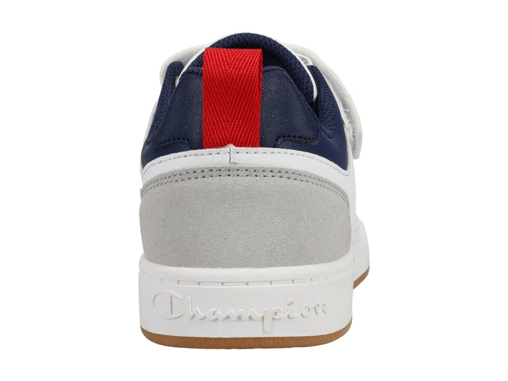 Tenis Champion blancos con detalles en gris y azul marino, correa ajustable y suela color caramelo.