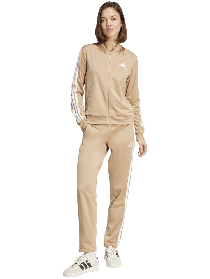 Conjunto deportivo Adidas Essentials color Warm Sandstone compuesto por chaqueta y pantalón con las tres franjas blancas.