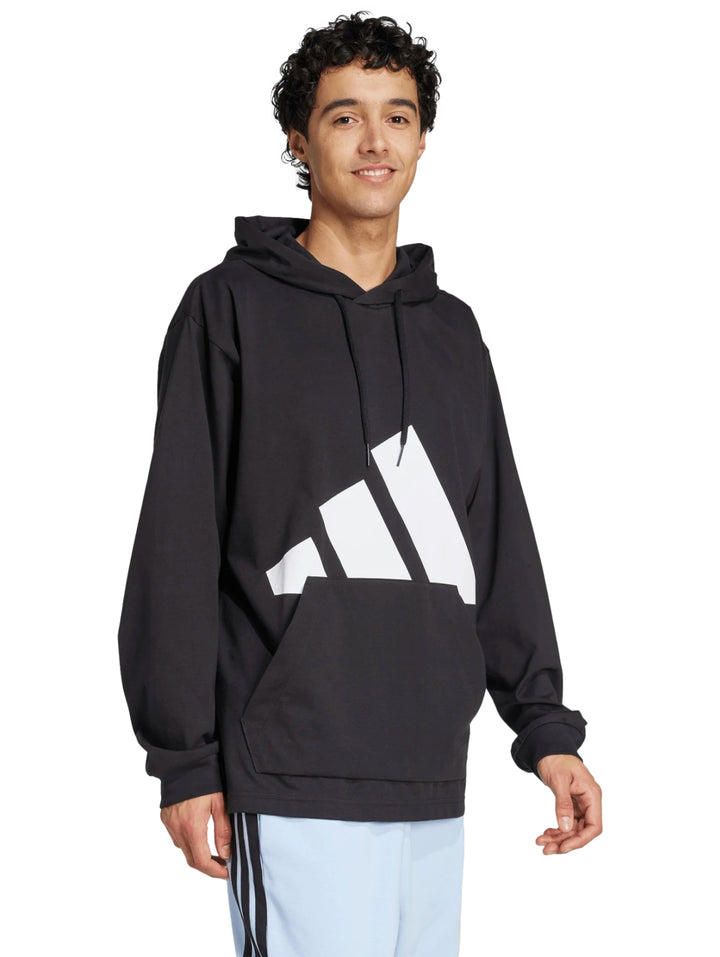 Hombre vistiendo sudadera negra con capucha y logo grande de Adidas en blanco.
