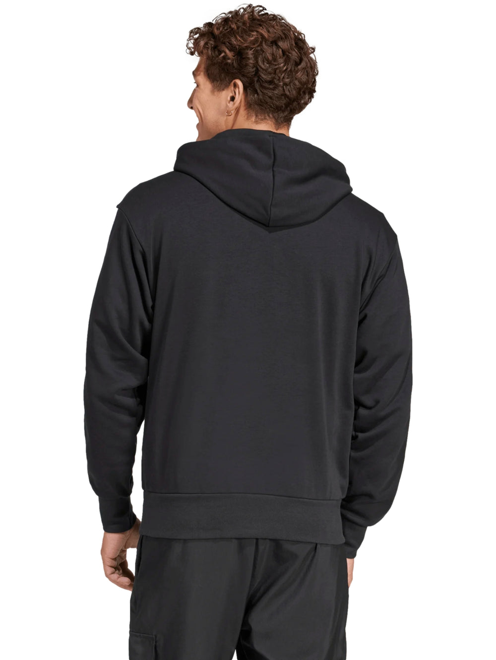 Hombre vistiendo sudadera negra con capucha y rayas blancas en las mangas de la marca Adidas.