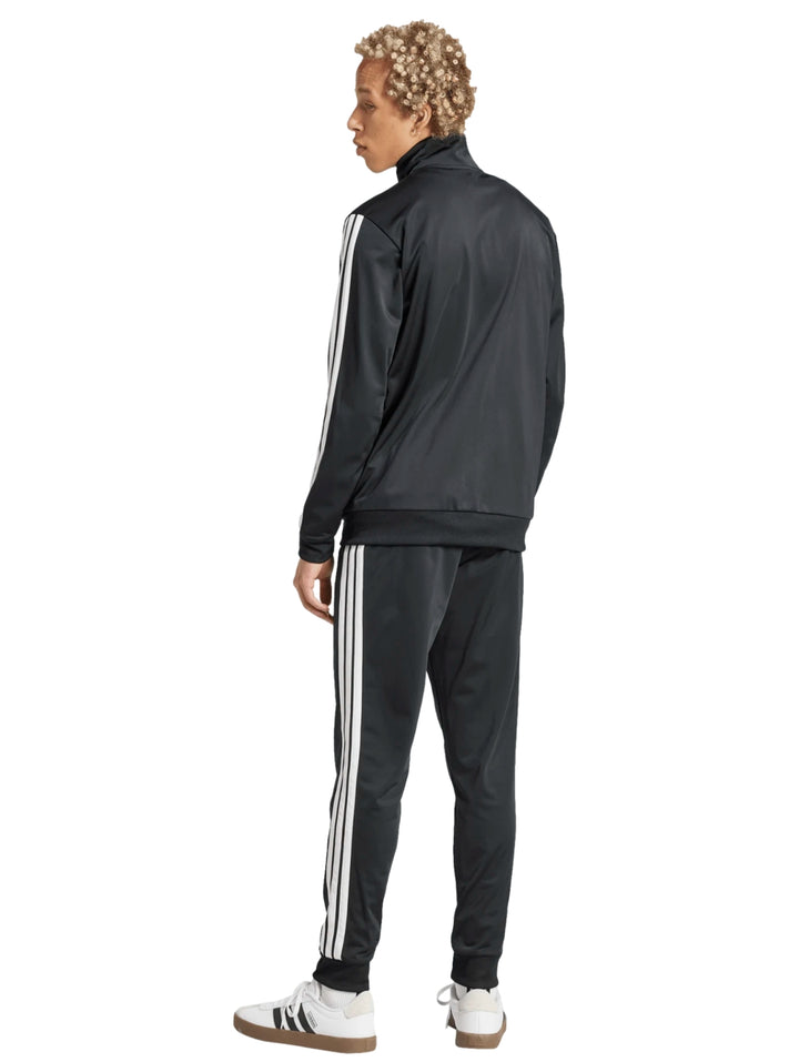 Conjunto deportivo Adidas negro compuesto por chaqueta y pantalón con tres franjas blancas laterales.