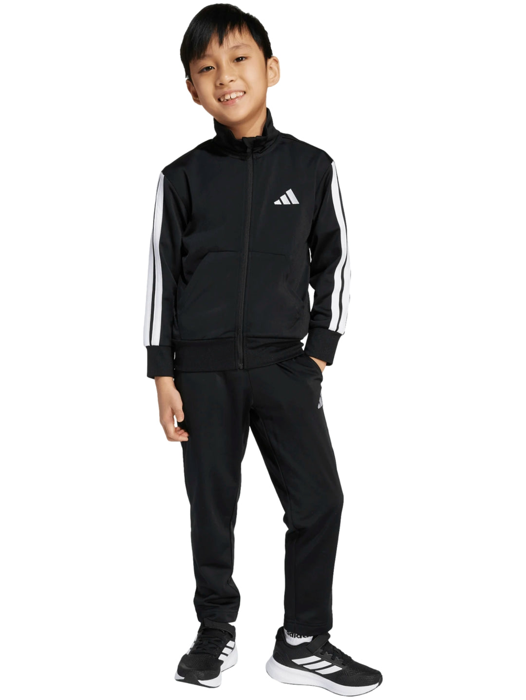 Niño vistiendo un conjunto deportivo Adidas de color negro con franjas blancas en las mangas y pantalones a juego.