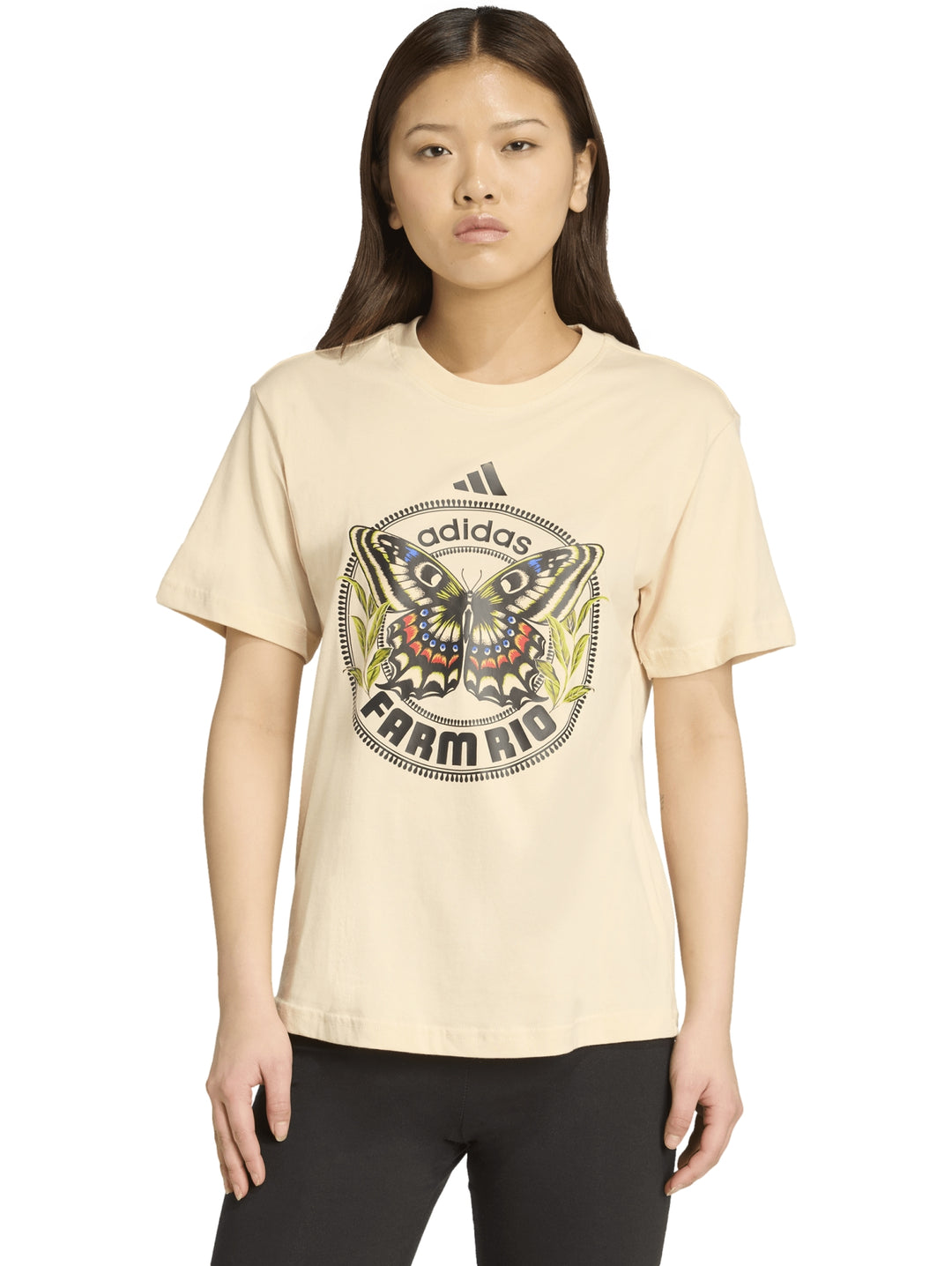 Camiseta beige Adidas x Farm Rio con un estampado central de una mariposa multicolor.
