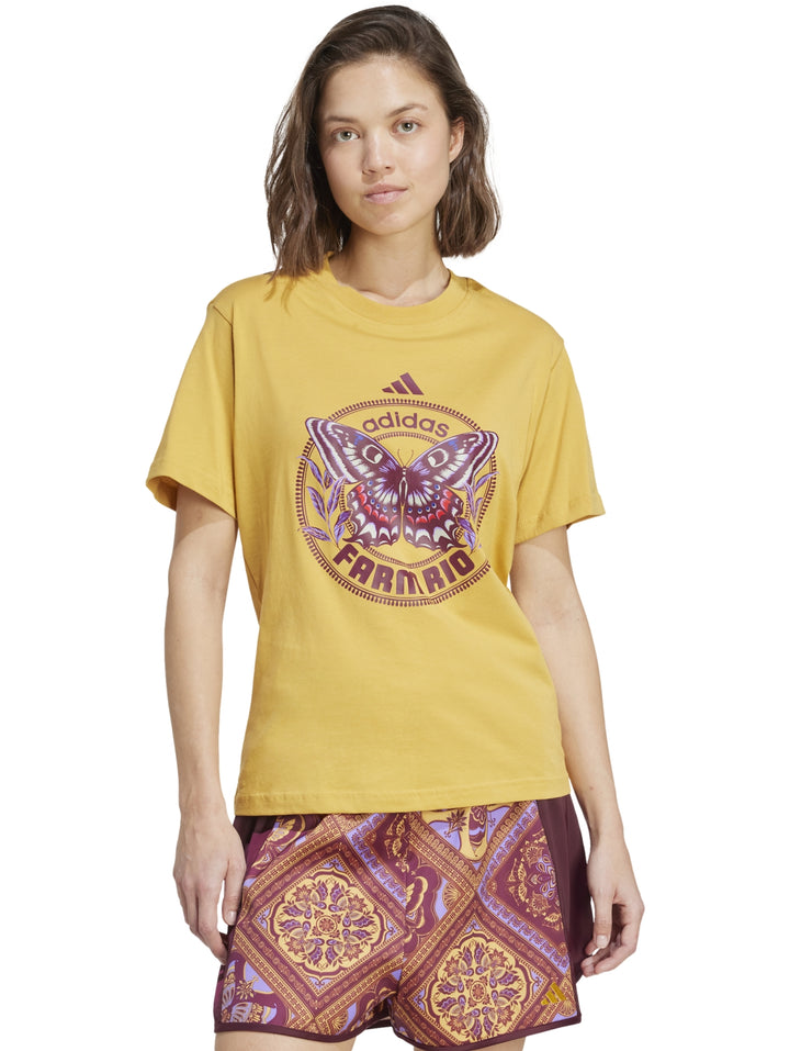 Camiseta Adidas color dorado con gráfico de mariposa en el centro y cuello redondo.