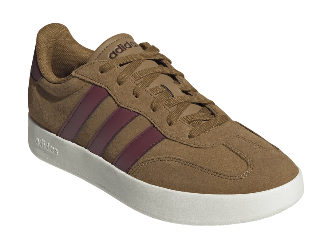 Tenis Adidas color café con franjas guindas y suela blanca.