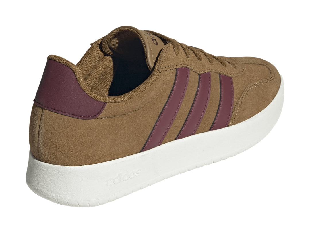 Tenis Adidas color café con franjas guindas y suela blanca.