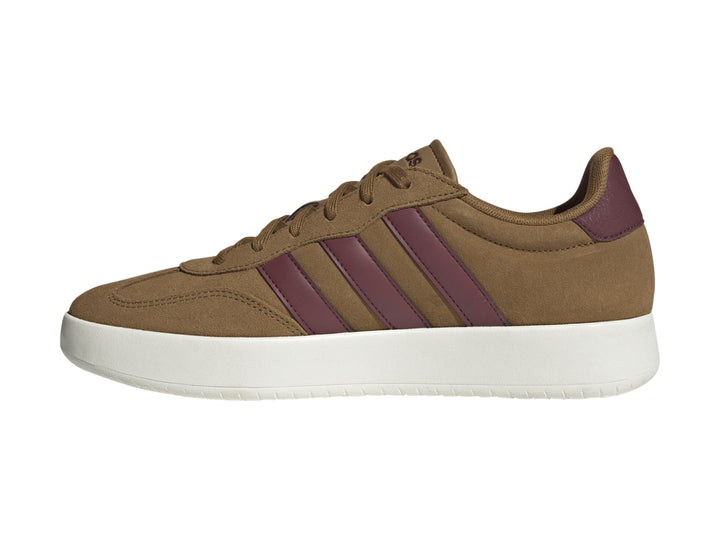 Tenis Adidas color café con franjas guindas y suela blanca.