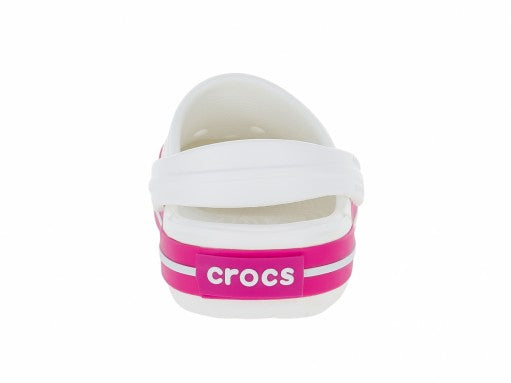 Zuecos Crocs blancos con rayas rosas en la suela para bebé o niño pequeño.