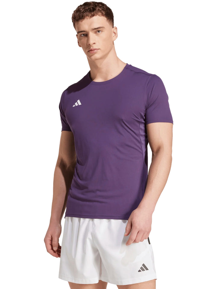 Hombre vistiendo playera de running Adidas color morado y shorts blancos.