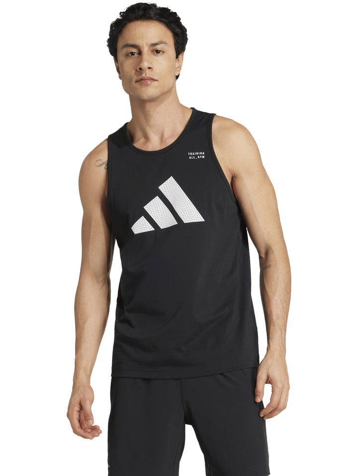 Hombre vistiendo playera sin mangas Adidas de color negro con logotipo blanco en el pecho.