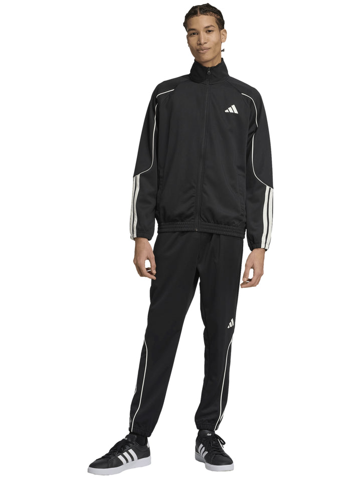 Hombre vistiendo un conjunto deportivo Adidas negro con franjas blancas laterales.