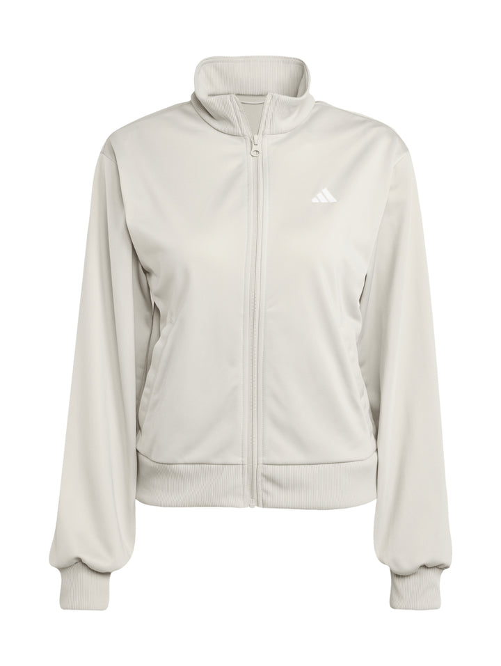 Conjunto deportivo Adidas Essentials Feel Cozy en color beige, compuesto por chaqueta y pantalón para mujer.