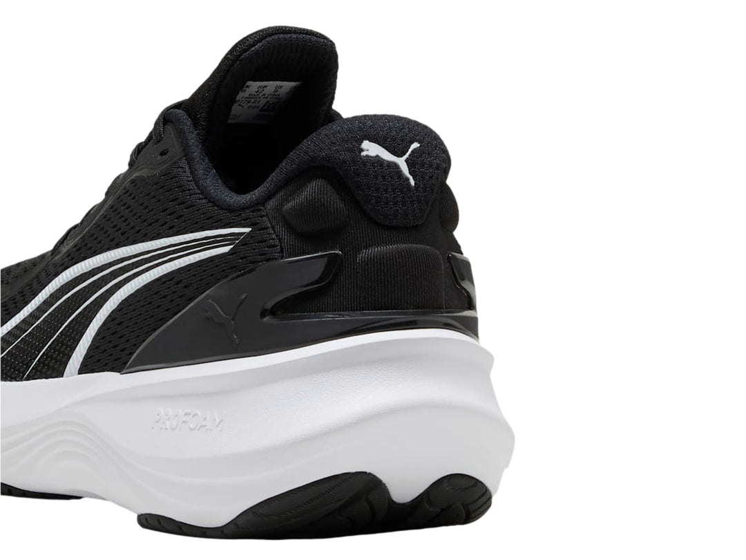 Tenis deportivos PUMA en color negro con suela blanca y logotipo blanco lateral.