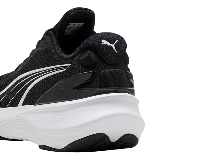 Tenis deportivos PUMA en color negro con suela blanca y logotipo blanco lateral.
