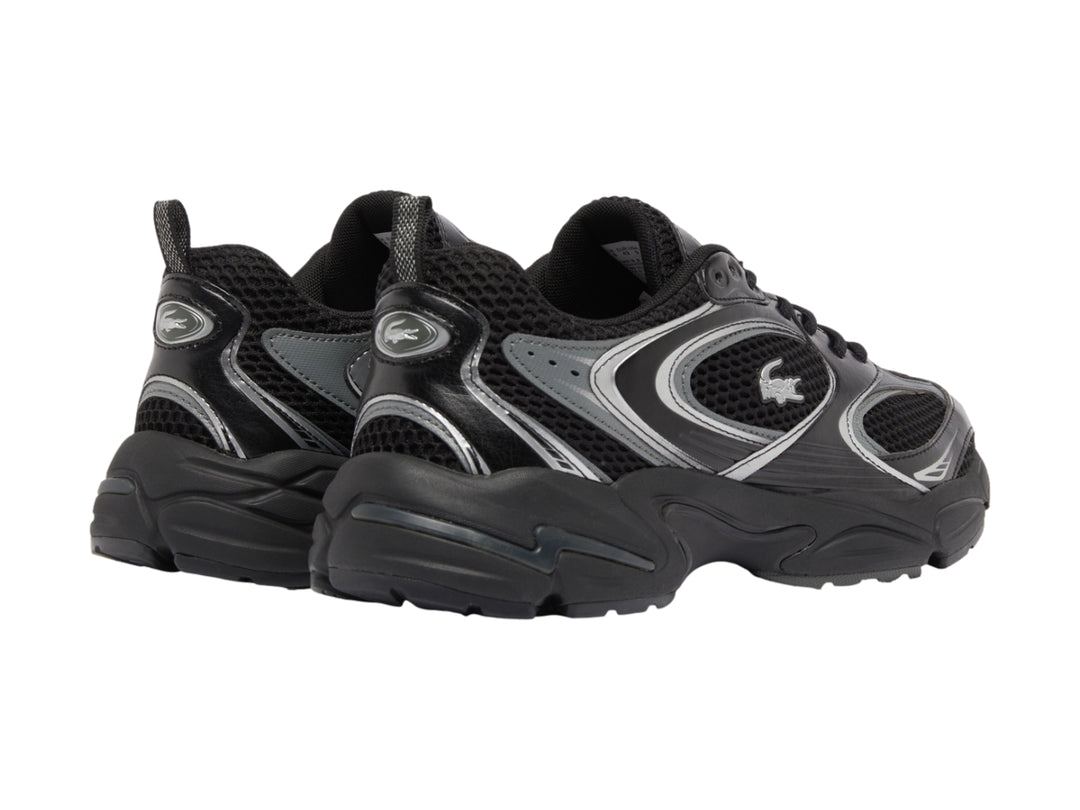 Tenis deportivos Lacoste color negro con detalles plateados y suela robusta.