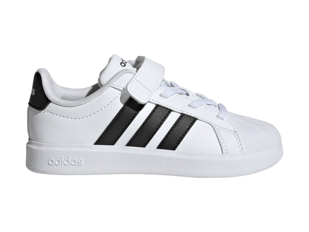 Tenis Adidas blancos con tres franjas negras y correa de velcro.