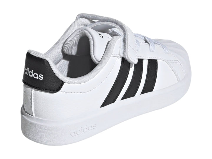 Tenis Adidas blancos con tres franjas negras y correa de velcro.