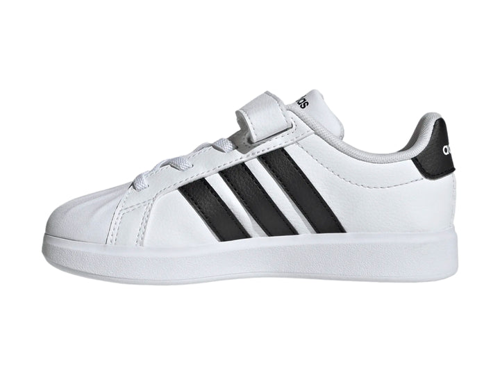 Tenis Adidas blancos con tres franjas negras y correa de velcro.