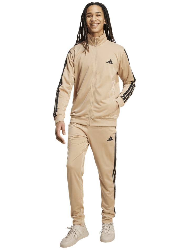 Conjunto deportivo Adidas color arena con tres franjas negras laterales, incluye chamarra y pantalón.