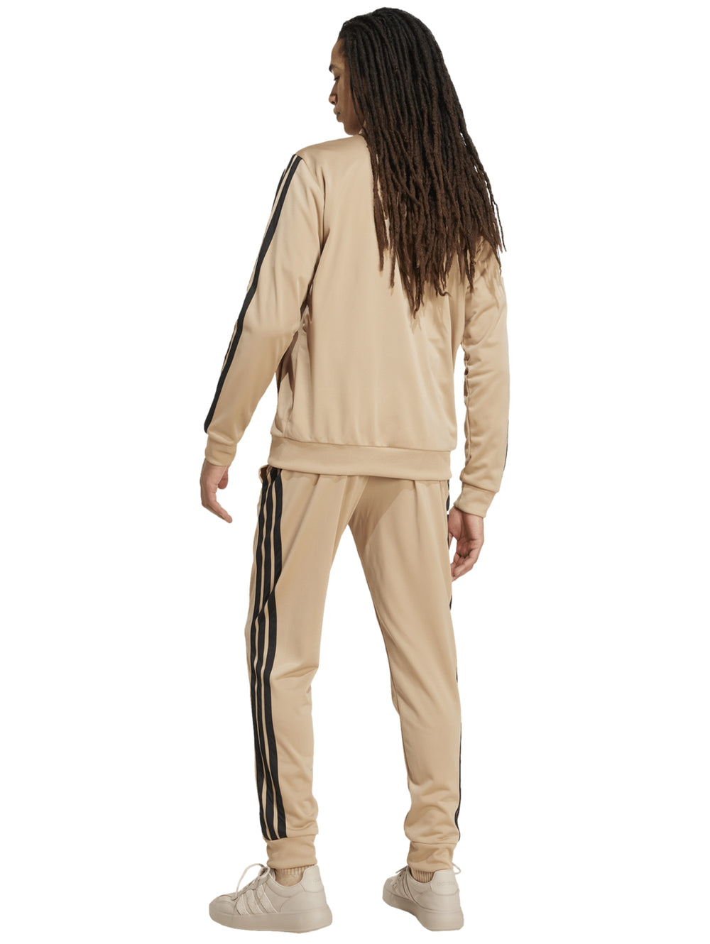 Conjunto deportivo Adidas color arena con tres franjas negras laterales, incluye chamarra y pantalón.