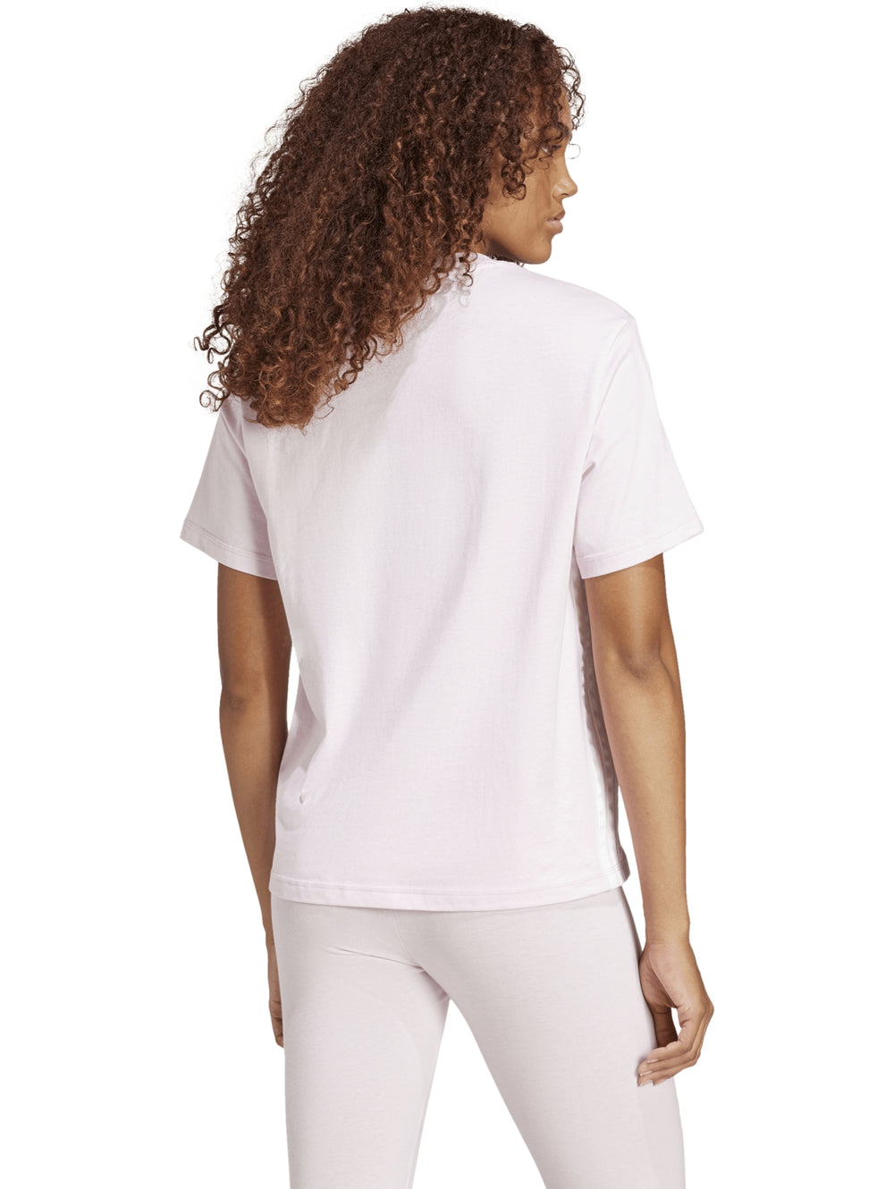 Mujer vistiendo camiseta deportiva Adidas de color rosa claro con logo en el pecho.