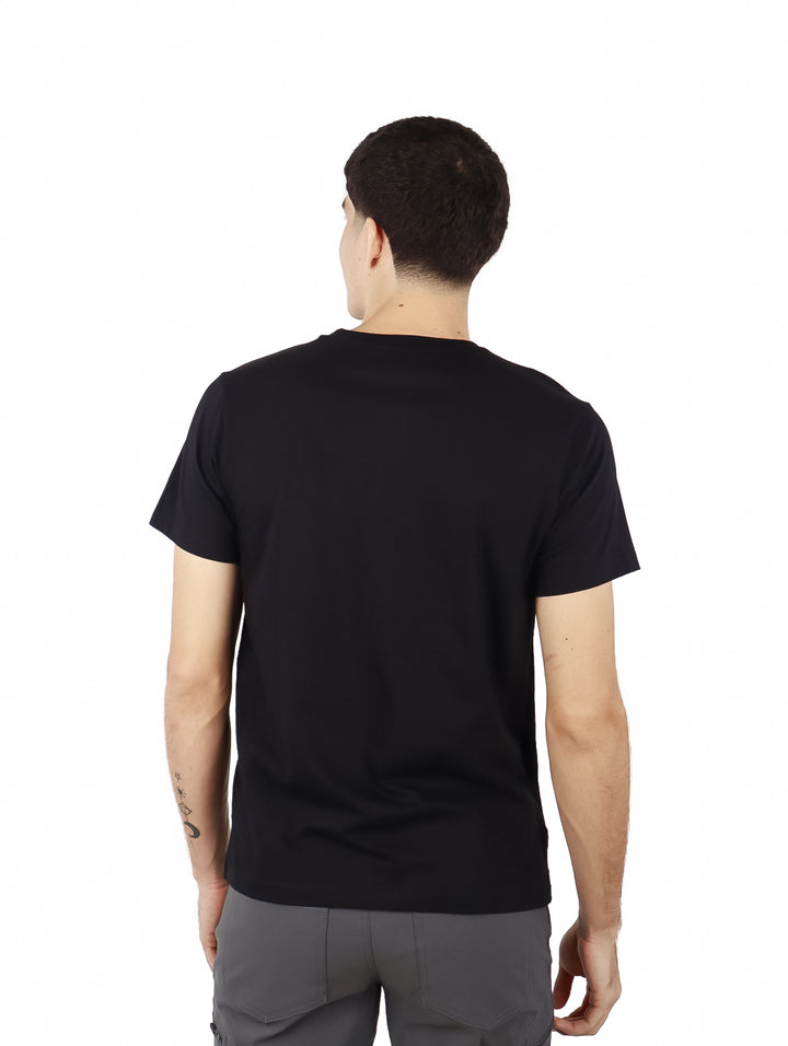 Hombre vistiendo playera negra de manga corta con estampado gráfico colorido en el frente.