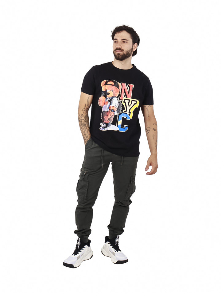 Hombre vistiendo playera negra de manga corta con estampado colorido de un oso y las letras NYC en el pecho.