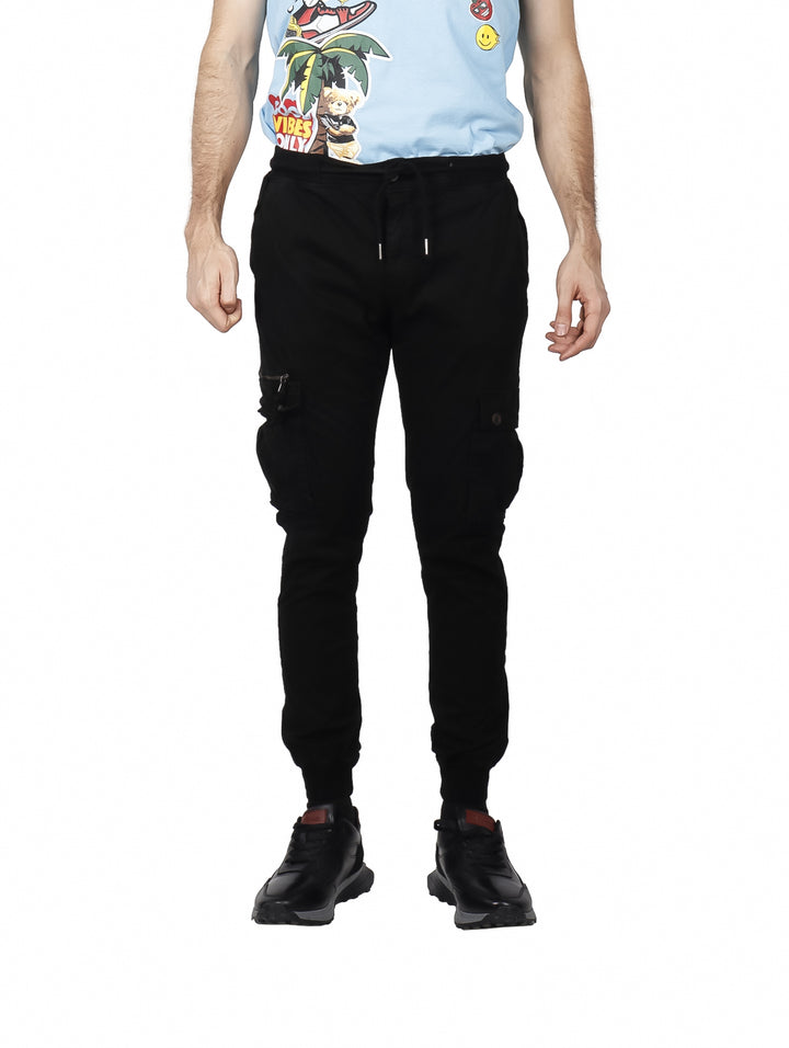 Hombre vistiendo pantalones jogger cargo color negro con bolsillos laterales y puños elásticos.