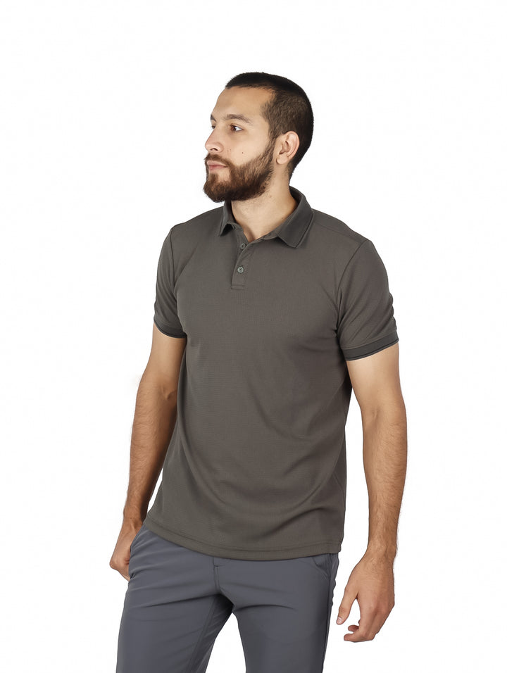 Hombre vistiendo una playera polo de color verde militar con cuello y manga corta.