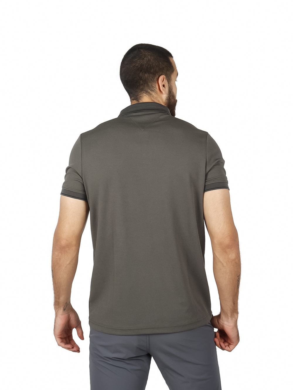 Hombre vistiendo una playera polo de color verde militar con cuello y manga corta.