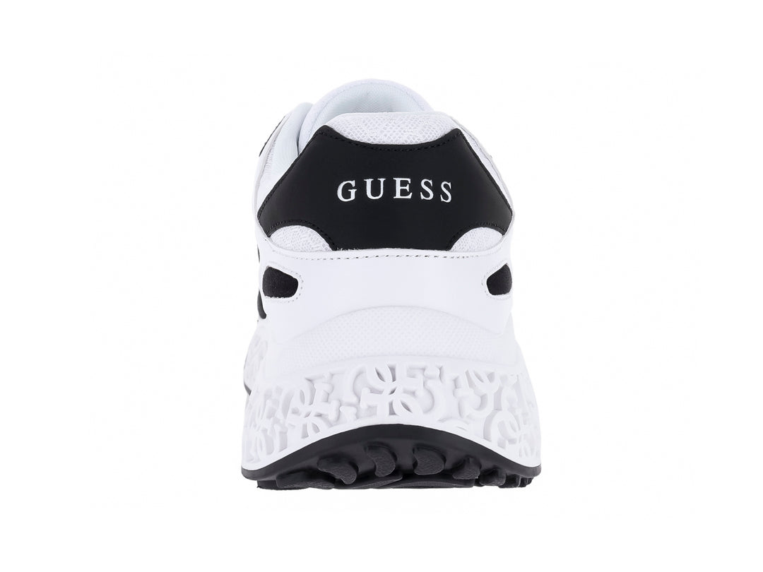 Tenis deportivos Guess color blanco con detalles negros y suela blanca gruesa.