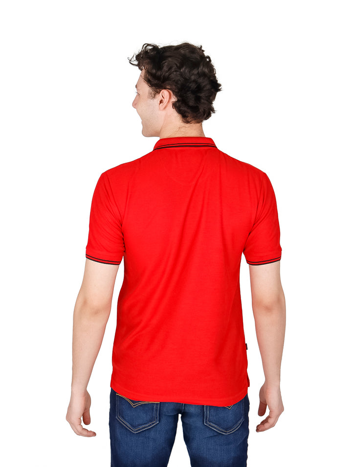 Hombre vistiendo una playera polo de color rojo con detalles negros en el cuello y mangas.