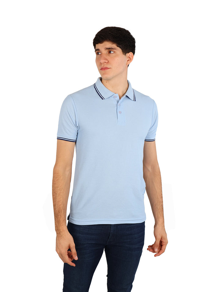 Hombre vistiendo una playera polo color azul cielo con detalles en azul marino en el cuello y mangas.