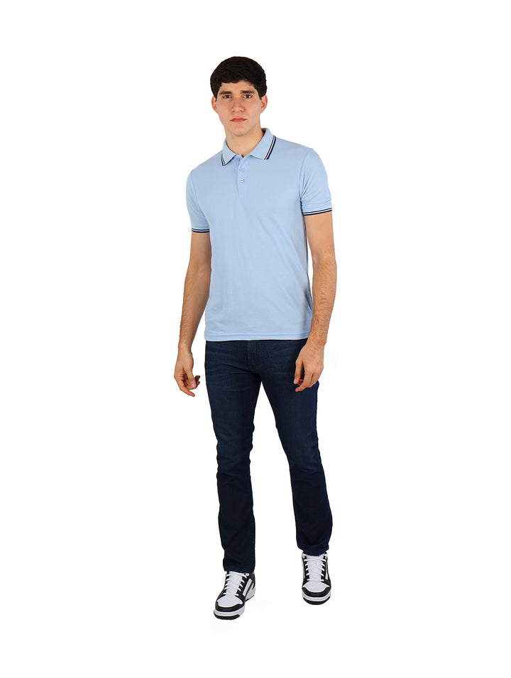 Hombre vistiendo una playera polo color azul cielo con detalles en azul marino en el cuello y mangas.