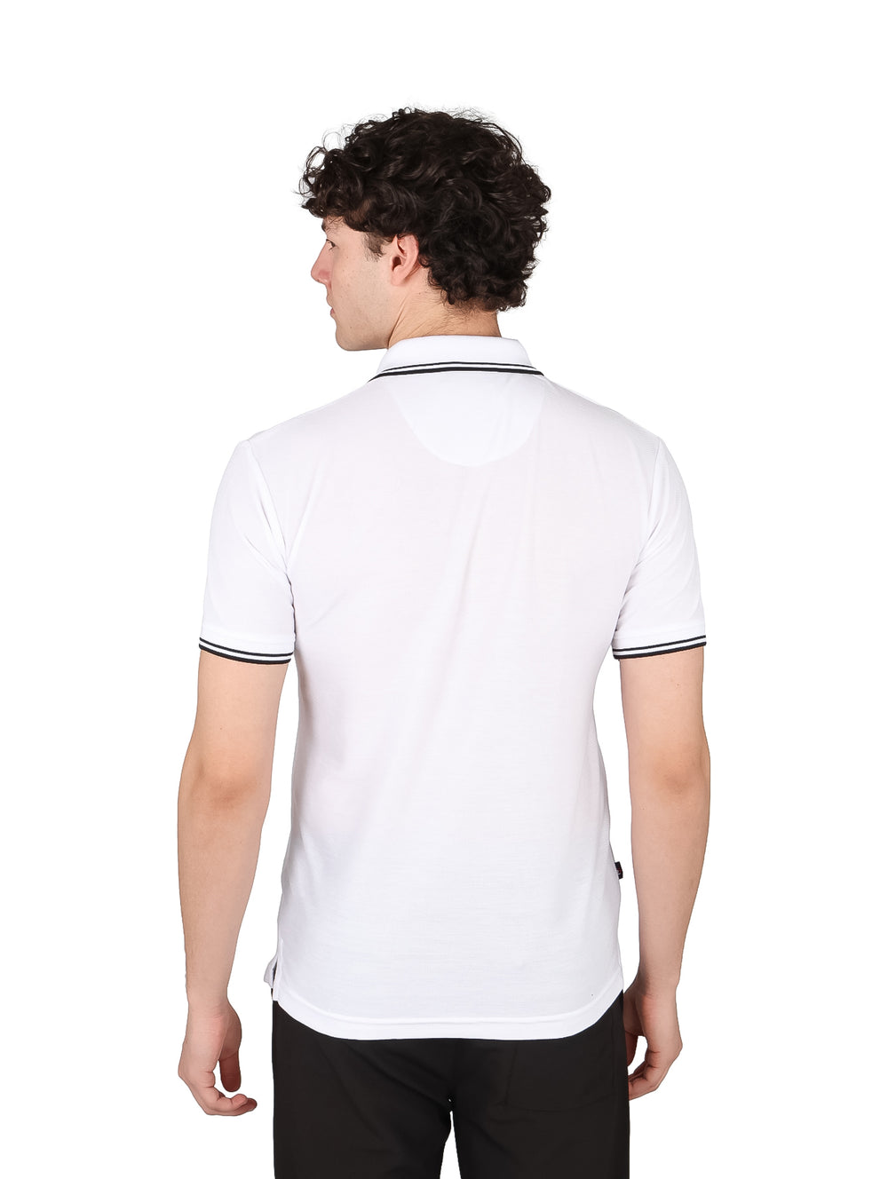 Hombre vistiendo una playera polo blanca con detalles negros en el cuello y los bordes de las mangas.