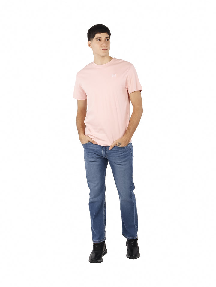 Hombre vistiendo una playera de manga corta color rosa baby.