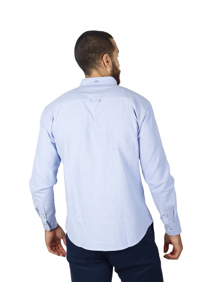 Camisa azul claro de manga larga con detalles de franjas rojas y azul marino en el pecho.