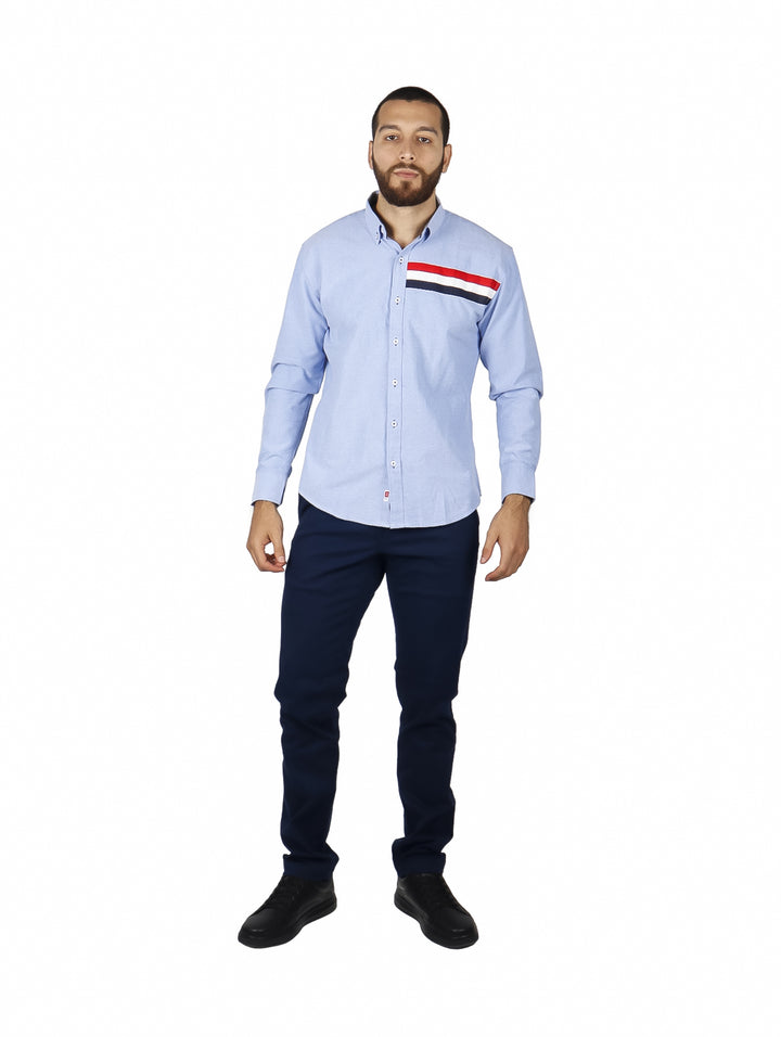 Camisa azul claro de manga larga con detalles de franjas rojas y azul marino en el pecho.