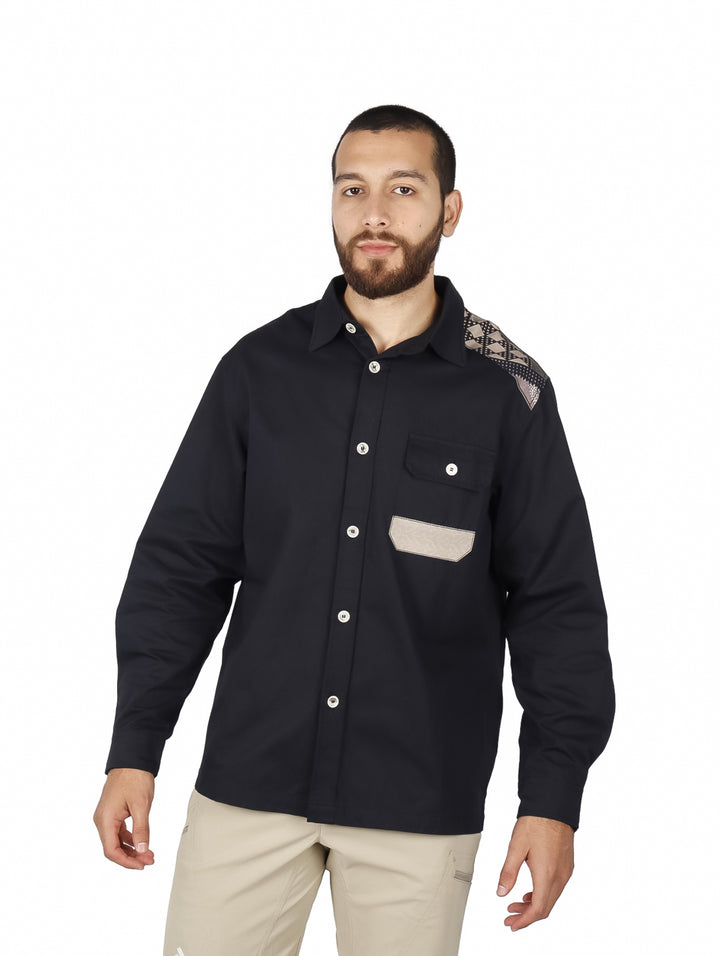 Sobrecamisa negra de manga larga con detalle estampado en el hombro y bolsillo frontal beige.