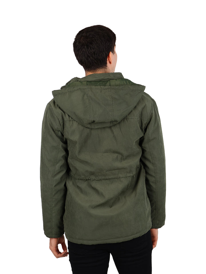 Hombre vistiendo una chamarra reversible color verde militar con capucha.