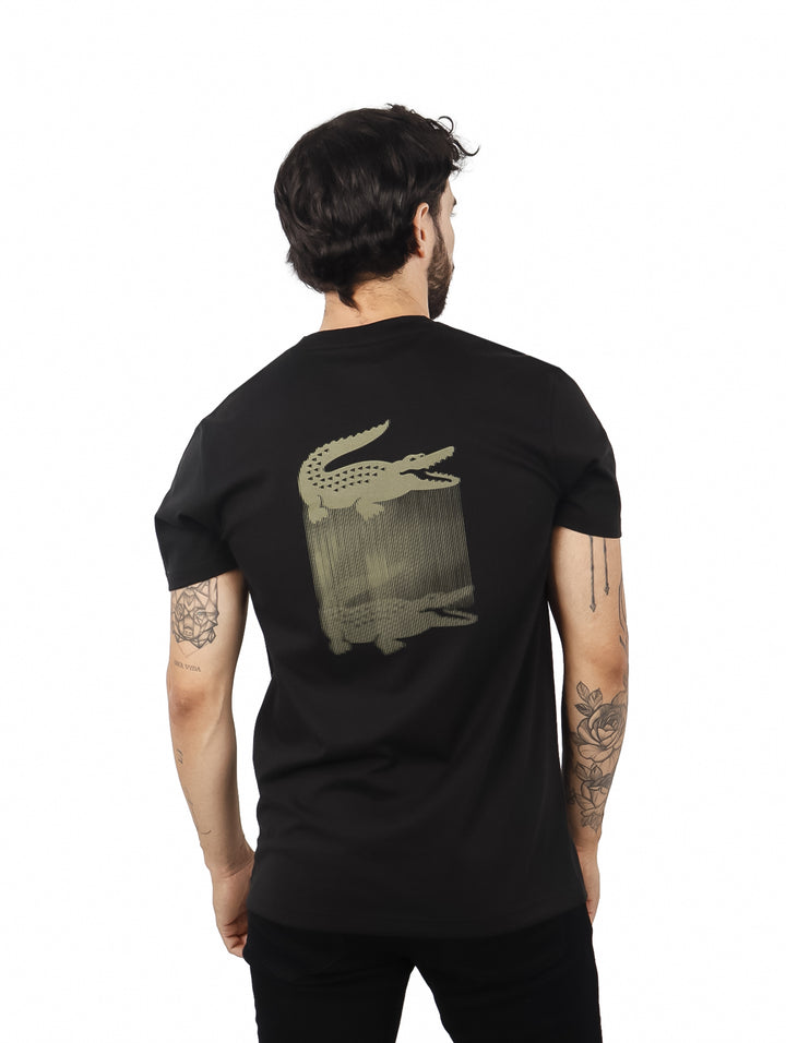 Hombre vistiendo una camiseta de manga corta color negro de la marca Lacoste.
