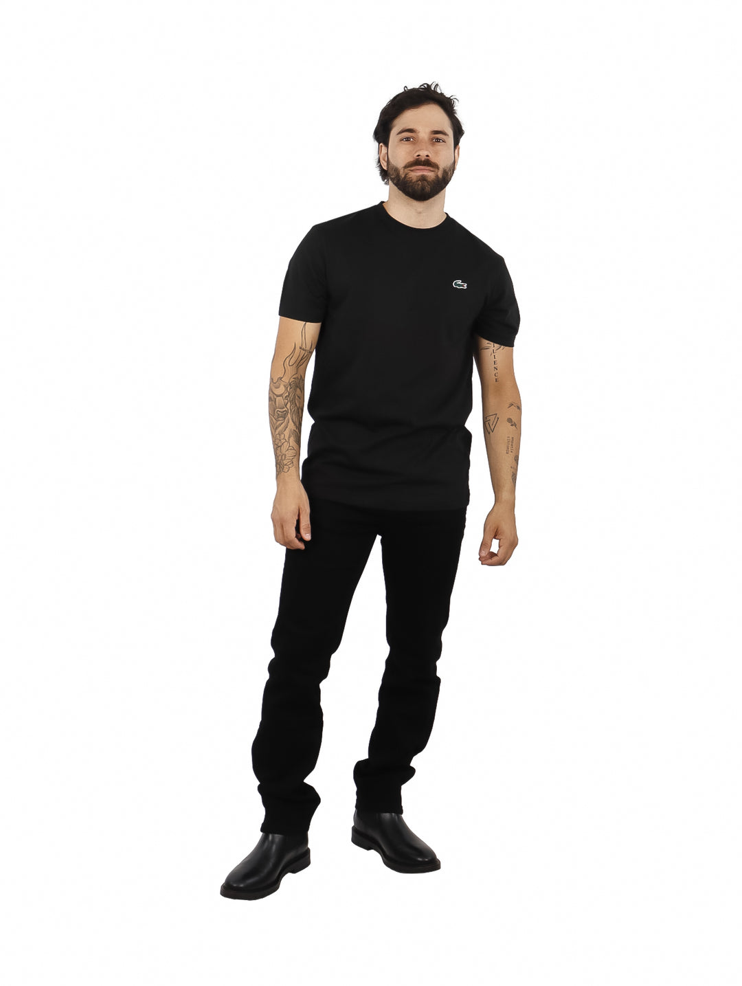 Hombre vistiendo una camiseta de manga corta color negro de la marca Lacoste.