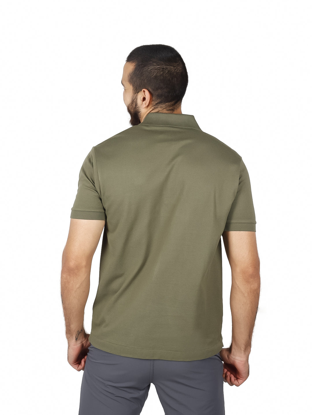 Hombre vistiendo una playera polo de color verde olivo de la marca Lacoste con cuello y manga corta.