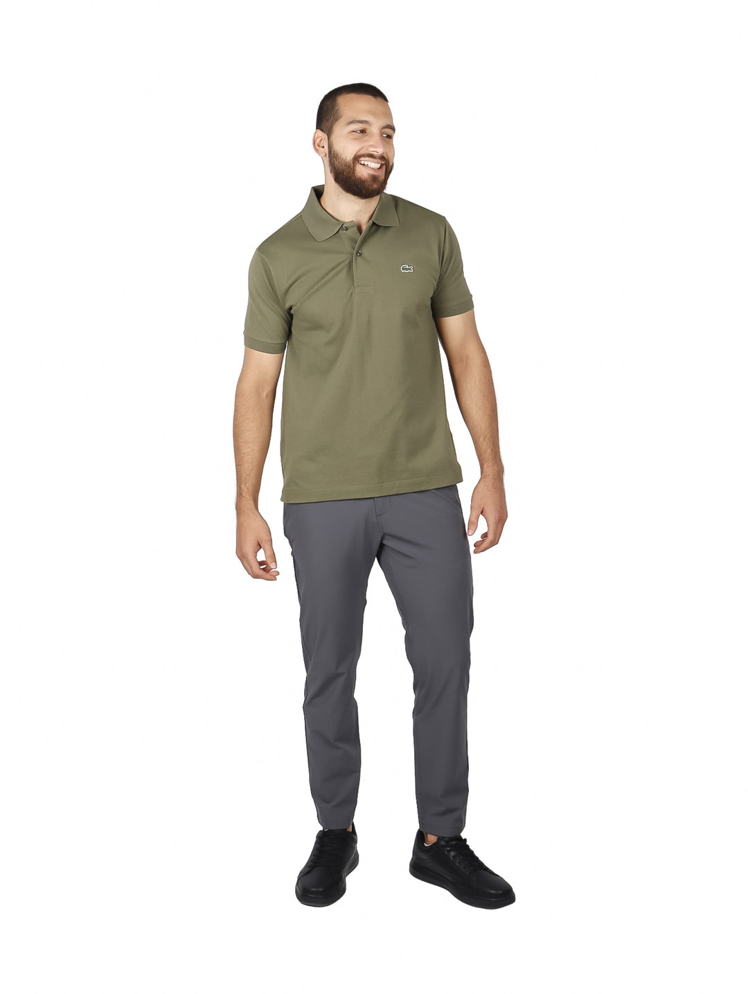 Hombre vistiendo una playera polo de color verde olivo de la marca Lacoste con cuello y manga corta.