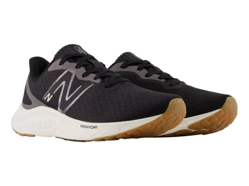 Tenis deportivos New Balance color negro con suela blanca y base café.