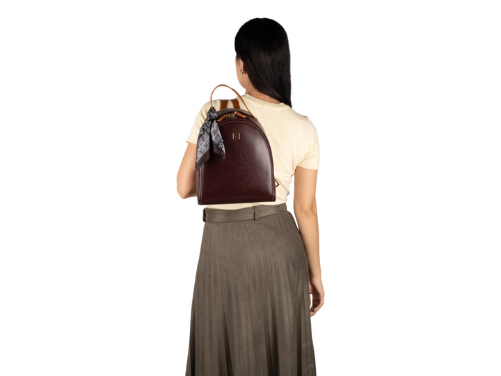 Mochila escolar Cloe color tinto con asa superior y un pañuelo decorativo gris.