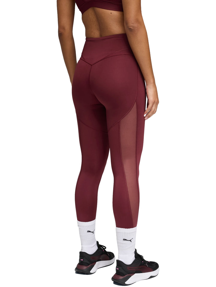 Mujer vistiendo leggings deportivos PUMA de color rojo vino, corte 7/8 y cintura alta.
